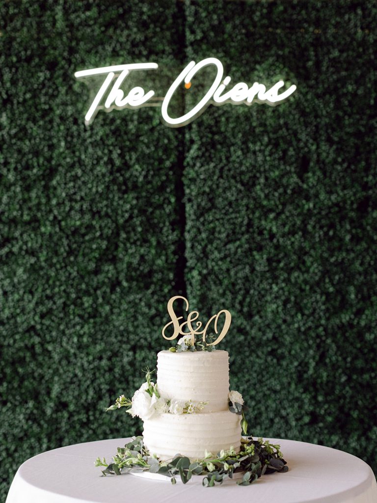 Wedding cake with hedge background and neon sign