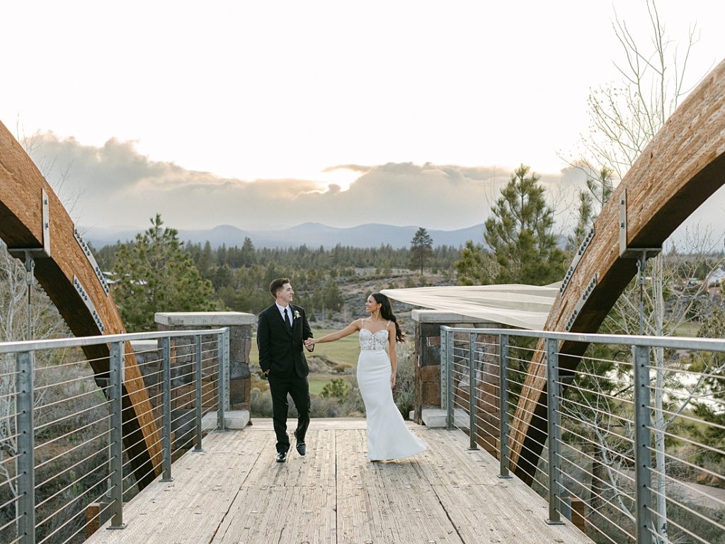 Bride and groom walking on a bridge