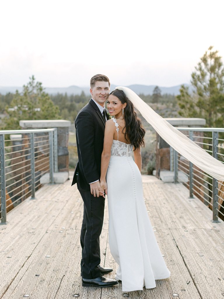 Bride and groom posing on a bridge