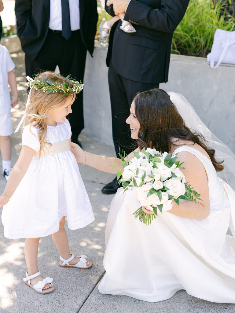 a woman in white dress holding a flower girl