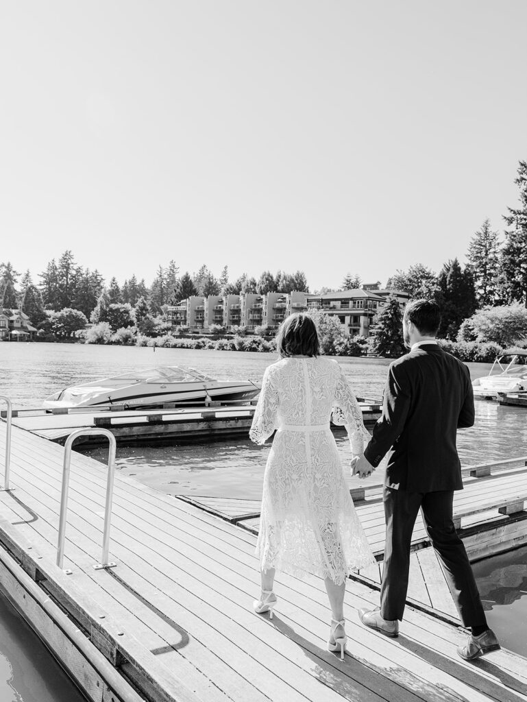 Couple walking along waterfront after wedding ceremony