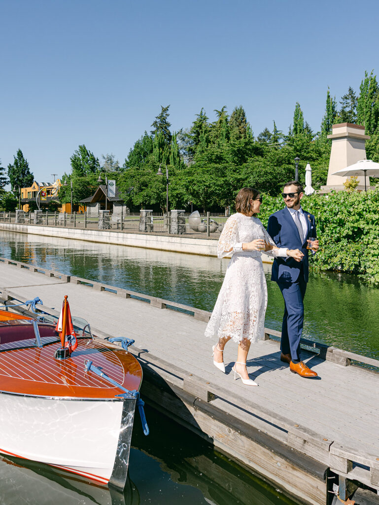 Couple walking along waterfront after wedding ceremony