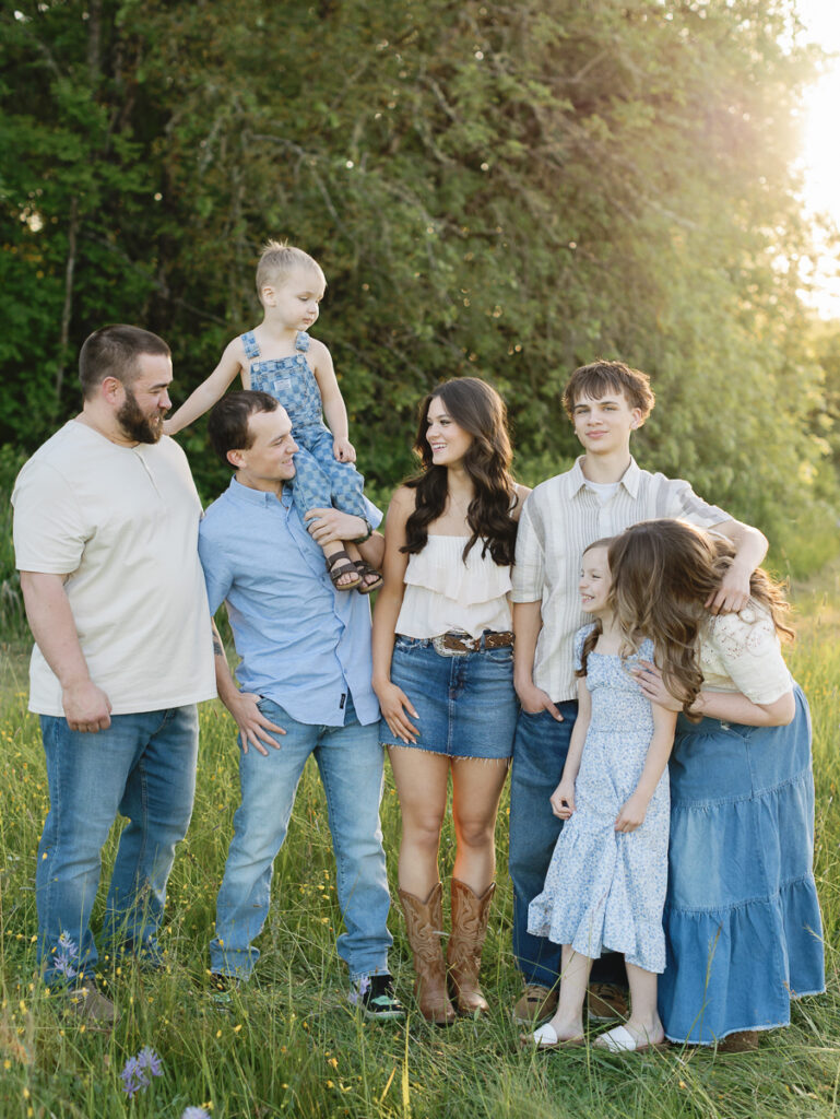 Family embracing in a field during a summer family photo session in Eugene Oregon